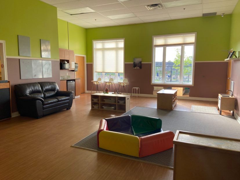 Classroom with couch, play mat and high chairs
