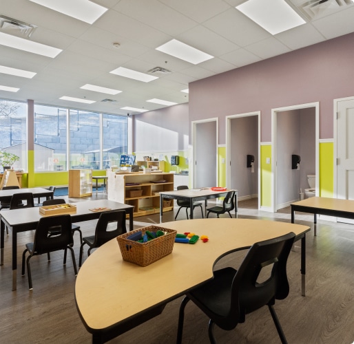 Bright classroom with desks, chairs, windows and bathrooms