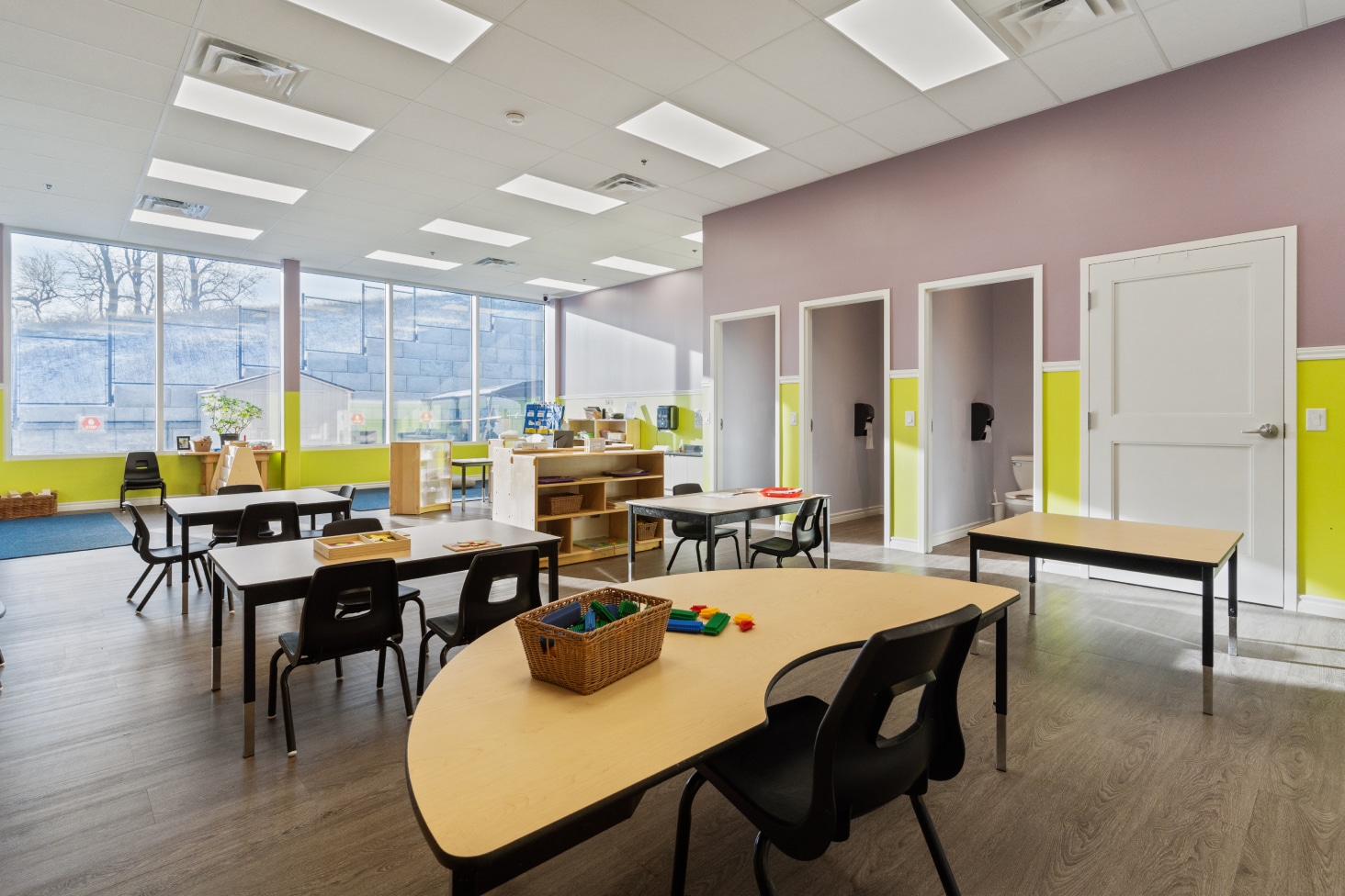 An early learning centre with tables and chairs in a purple and yellow color scheme.