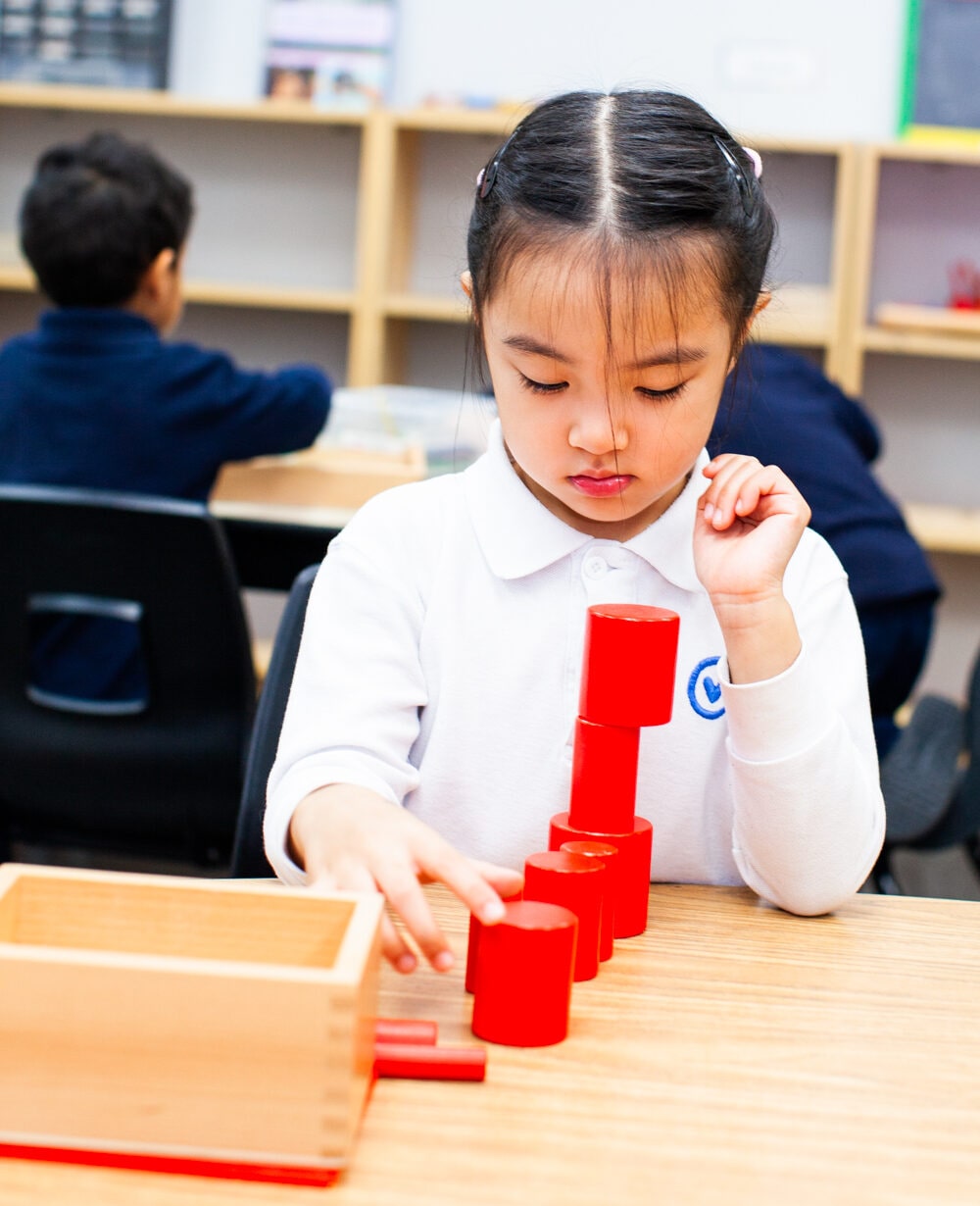 Girl building tower with red blocks