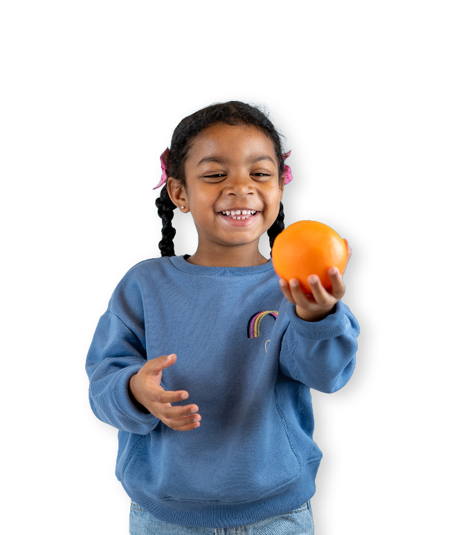Girl wearing blue sweater holding an orange
