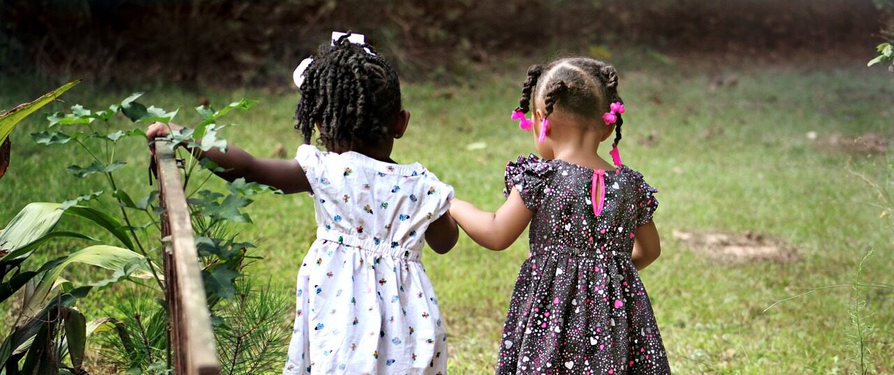 Two girls walking through park