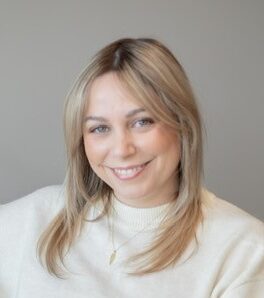 Team member wearing white and smiling at the camera